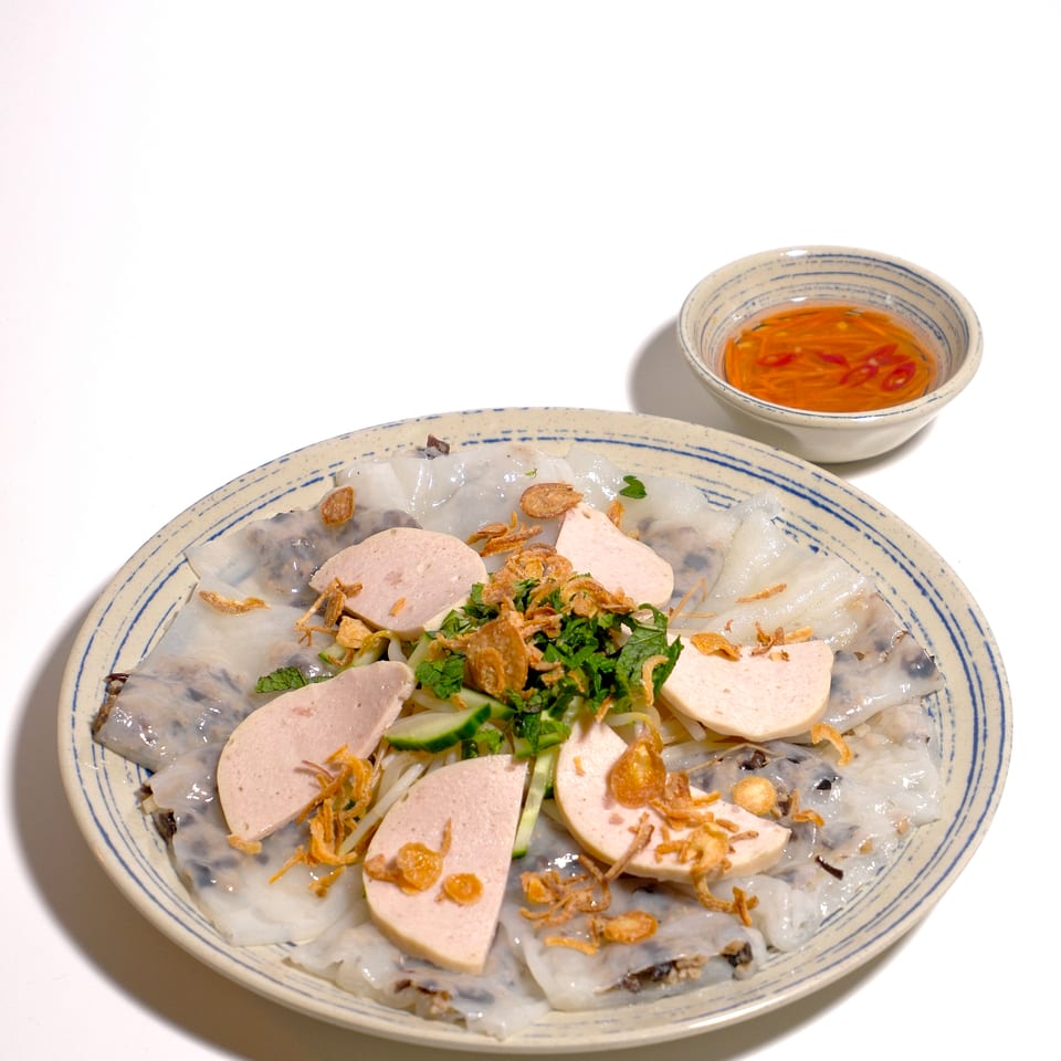 Vietnamese steamed rice rolls topped with pork sausage, herbs, cucumber, and fried shallots, served with chili dipping sauce.